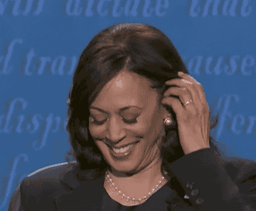 Vice President Kamala Harris tucking her hair behind her ears and putting her chin on her hands in an &quot;I&#x27;m listening&quot; way