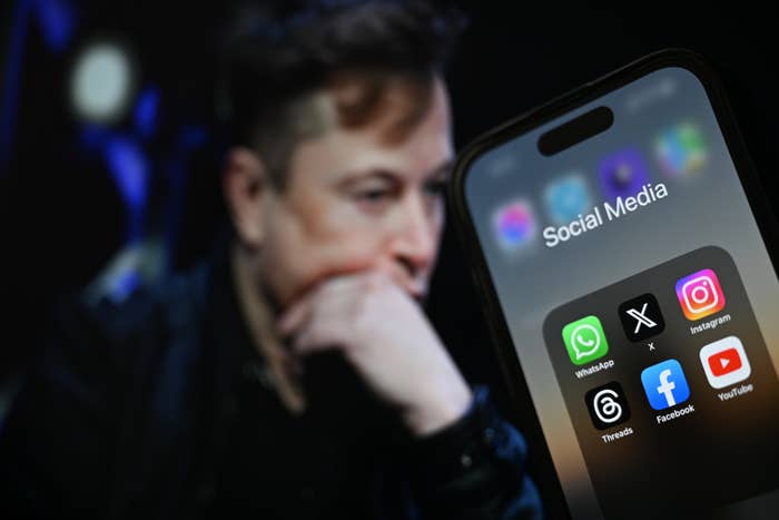 A phone with social media apps in front of Elon Musk&#x27;s face