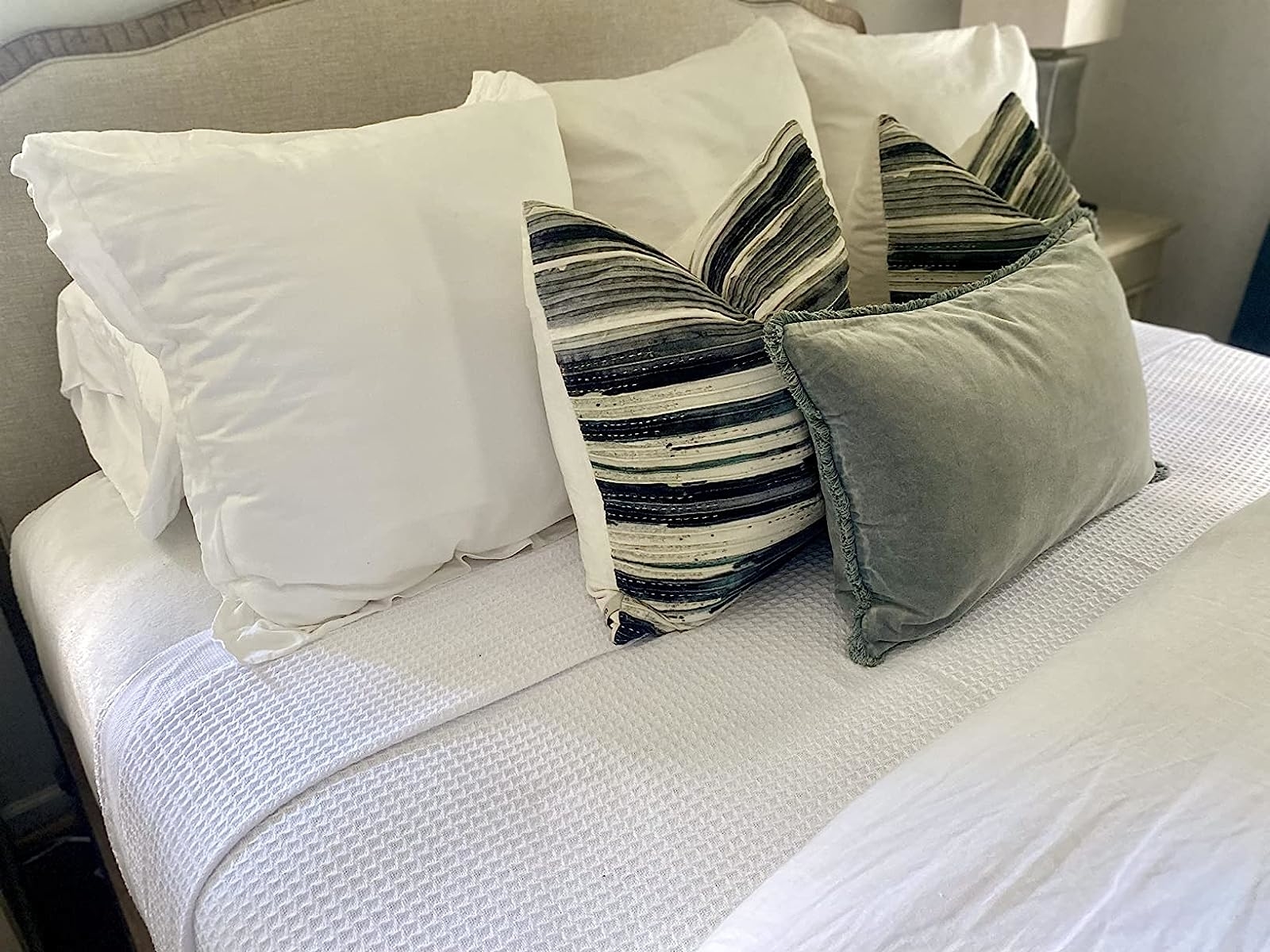 Reviewer image of the blanket on their bed with gray and white bedding