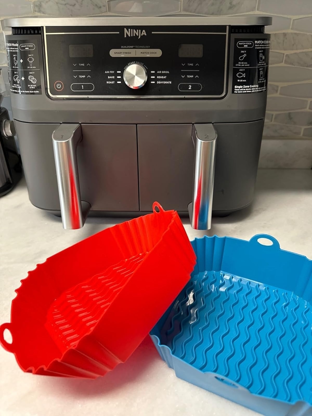 red and blue air fryer liners in front of Ninja air fryer