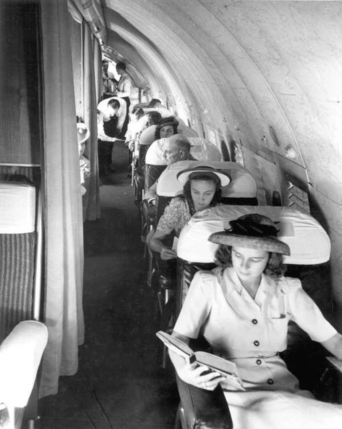 Women wearing dresses and hats in rows with single seats