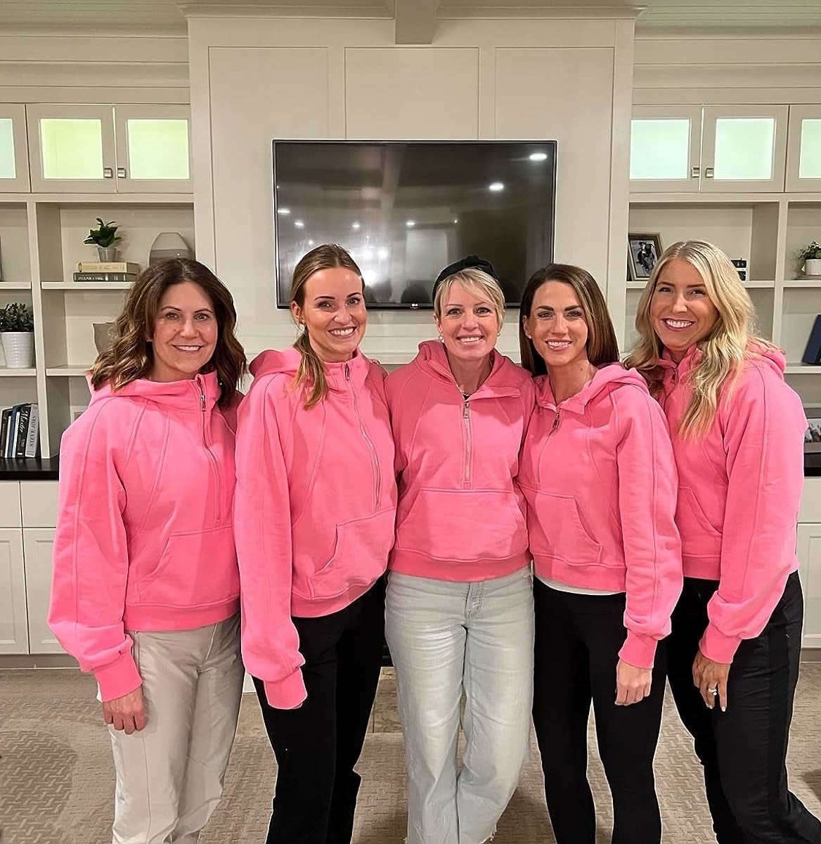 Reviewer and their friends all wearing the pink hoodies