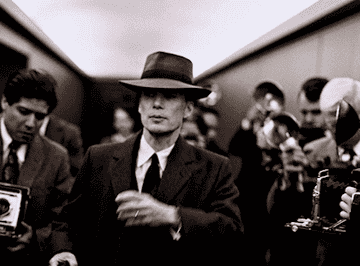 Cillian Murphy walks down a hallway filled with photographers