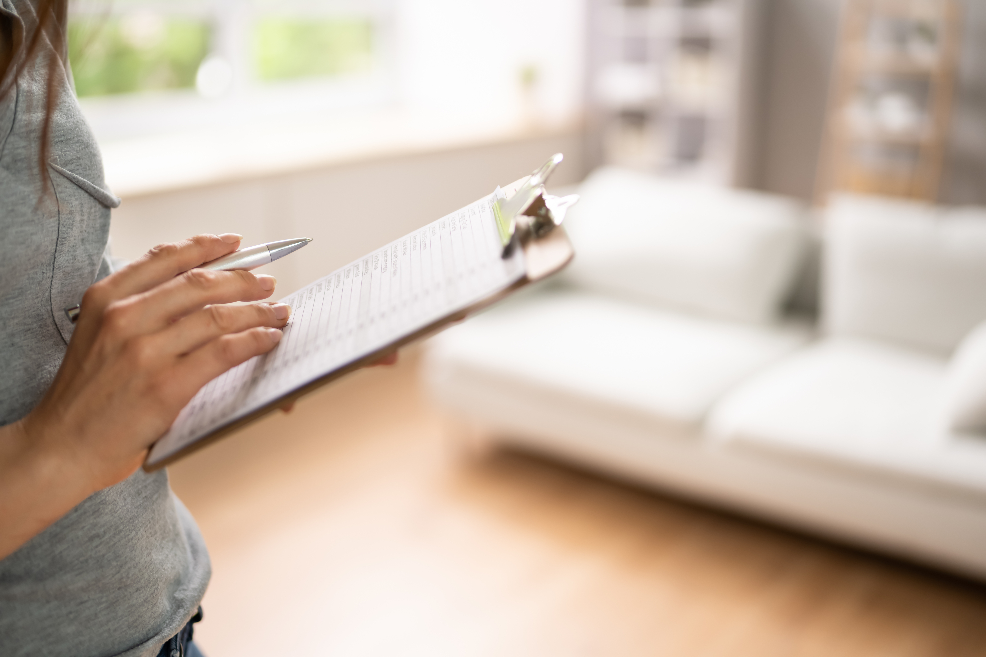 A woman filling out a paper on a clipboard