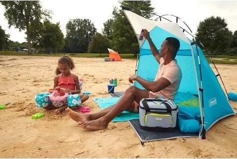 Adults and kids use tent at the beach