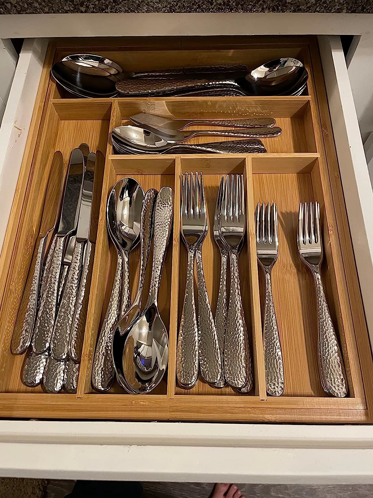 Reviewer&#x27;s tray organizing silverware in drawer