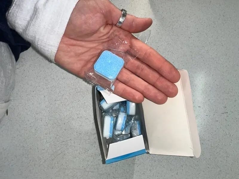 Reviewer showing one of the washing machine cleaner tablets