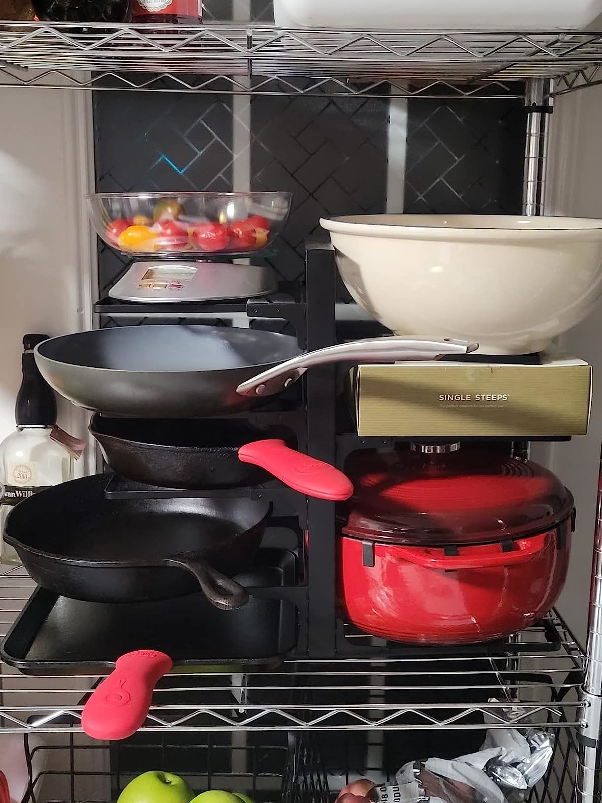Reviewer's rack with cast iron pans, dutch oven, and ceramic bowl being stored on shelves