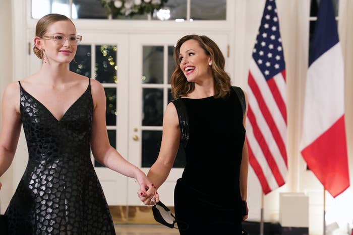 the two holding hands as they walk through the white house
