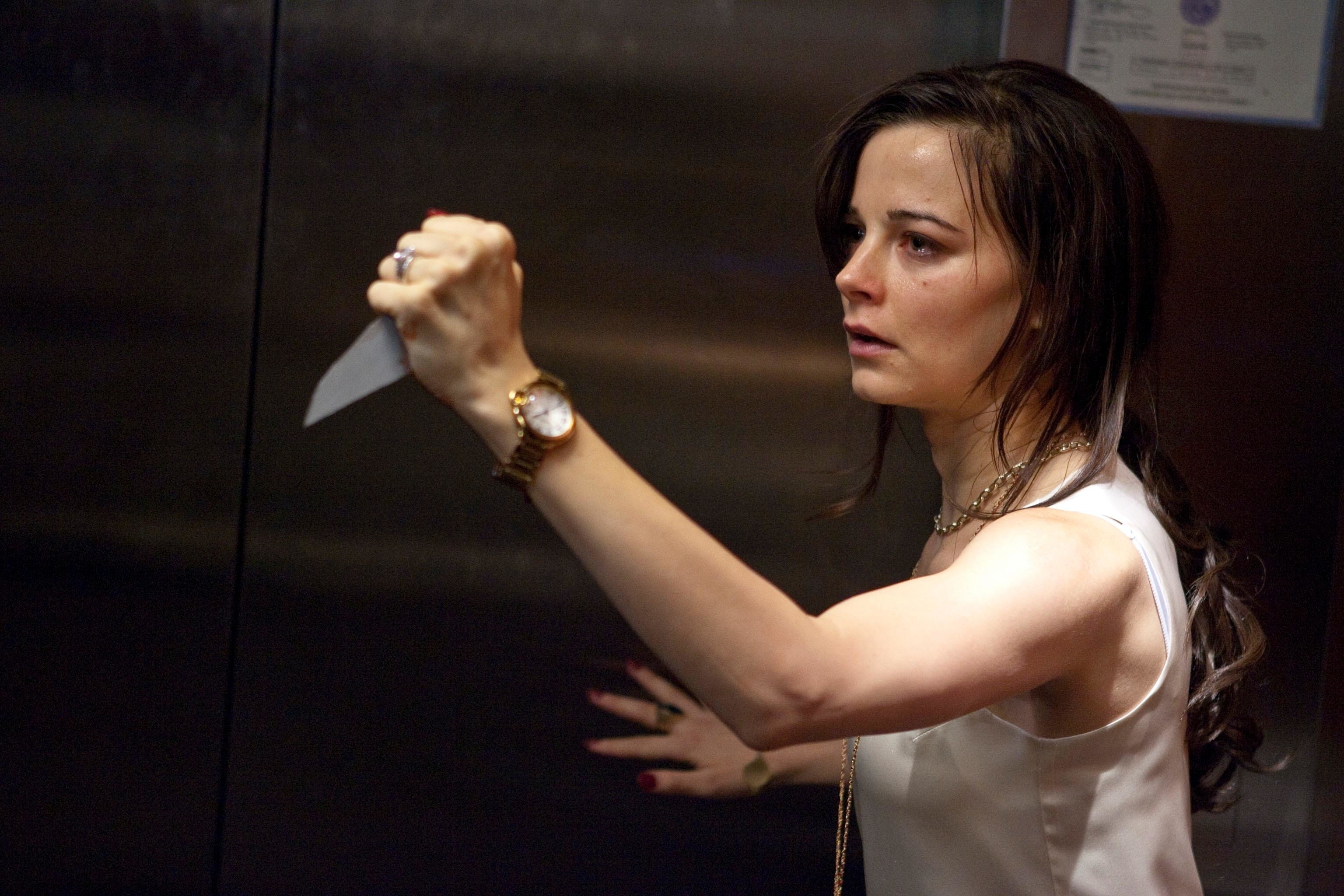 Bojana Novakovic defensively holds a shard of glass on an elevator