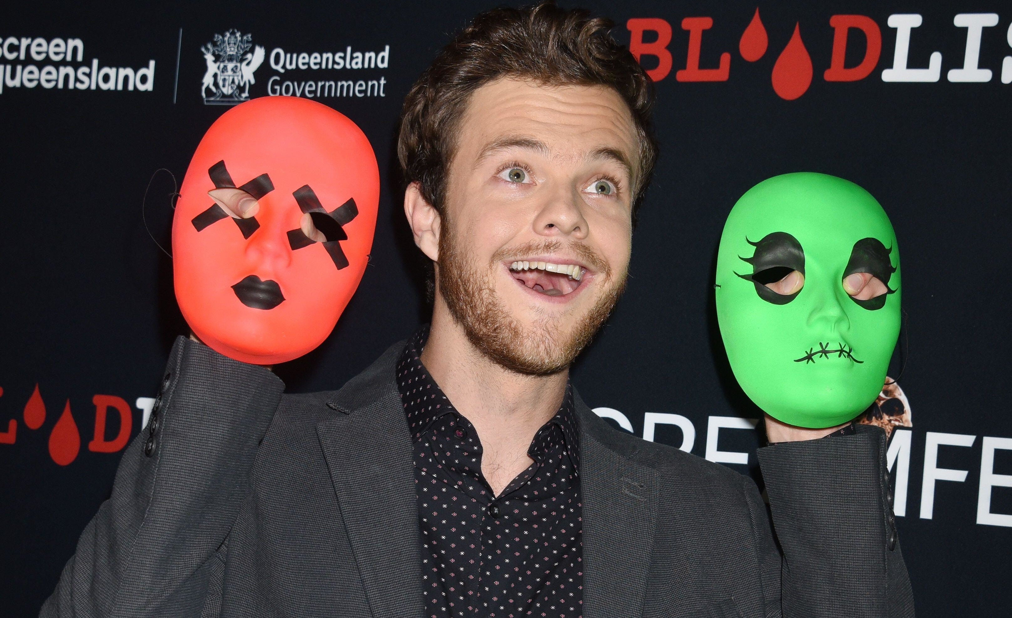 Jack Quaid attending the &#x27;Tragedy Girls&#x27; Screamfest 2017 Los Angeles Premiere holding up two masks