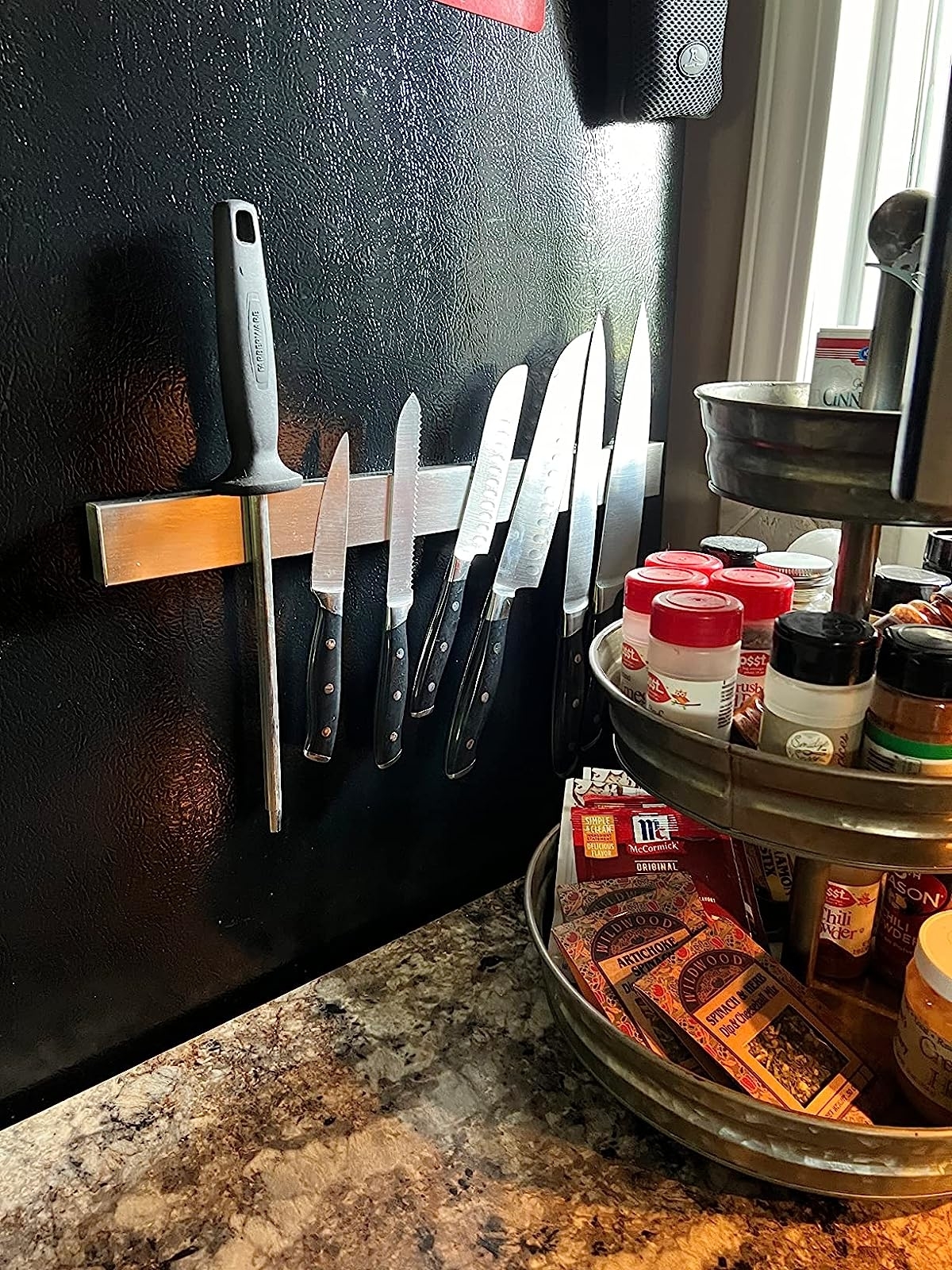 Reviewer's knives on rack on side of fridge