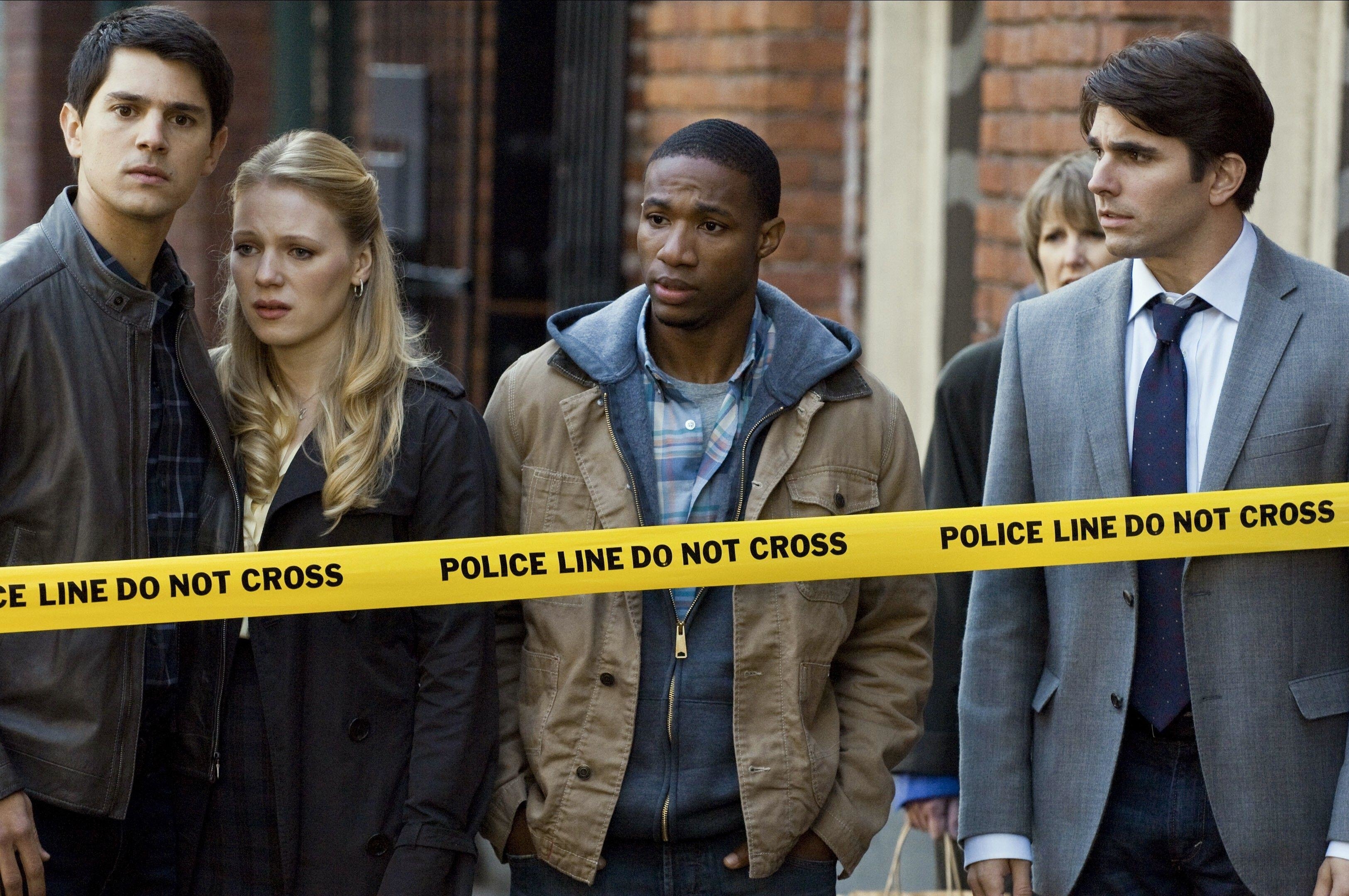 The cast of Final Destination look concerned near a crime scene sectioned off by police tape