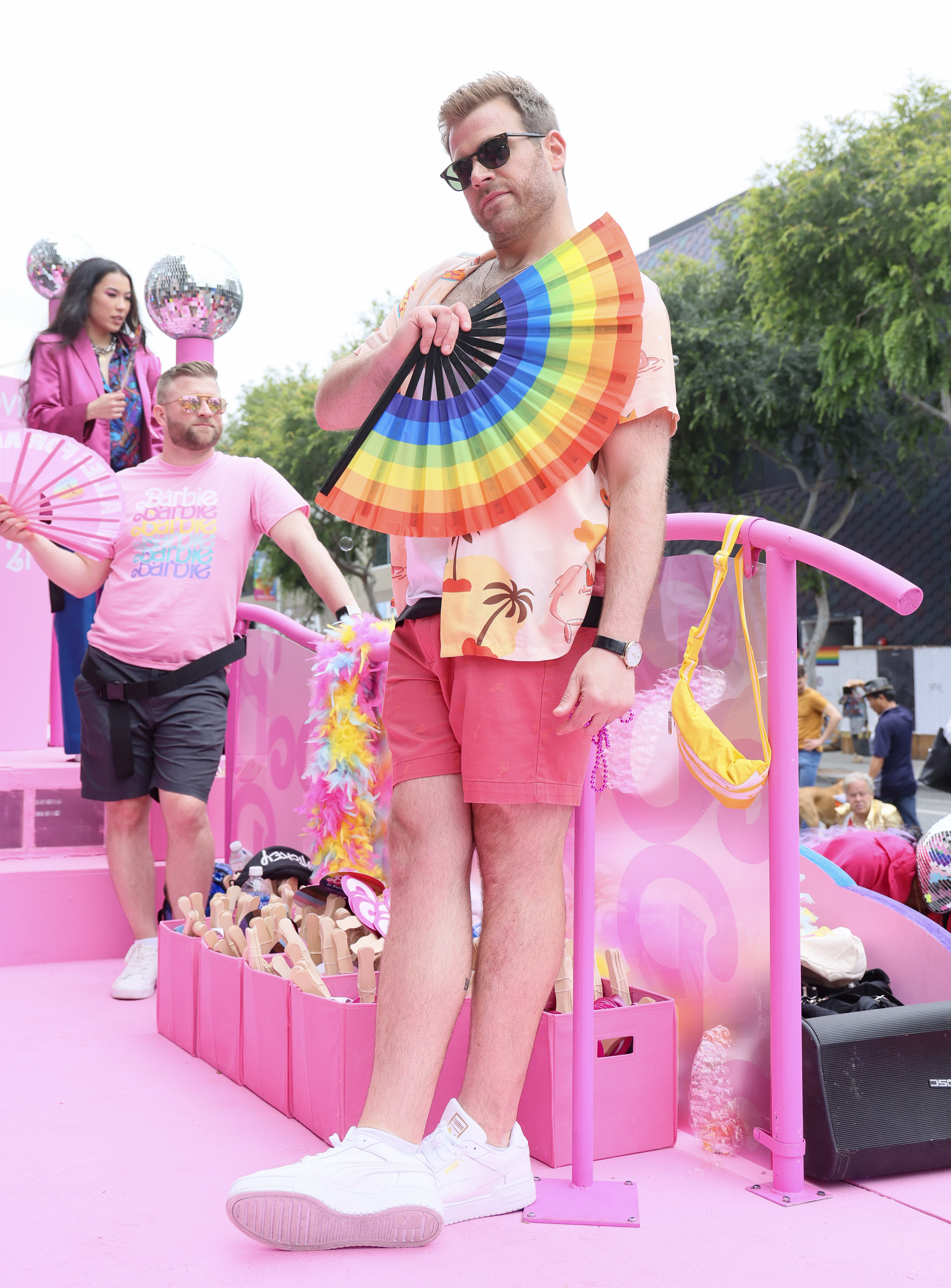Scott Evans posing with a rainbow fan on the pride float