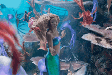 ariel swimming happily among the fishes