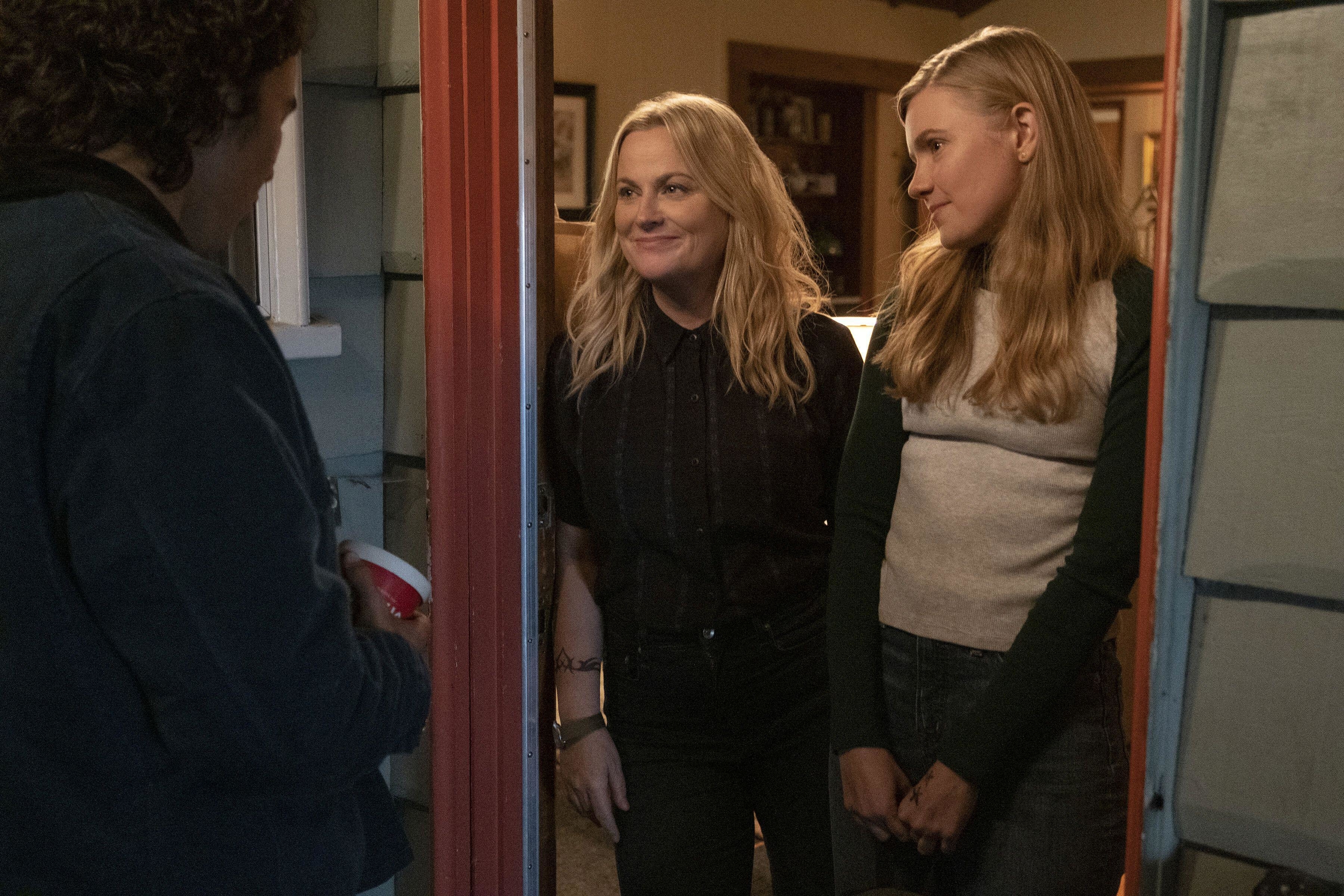 Hadley Robinson and Amy Poehler standing in a doorway in Moxie