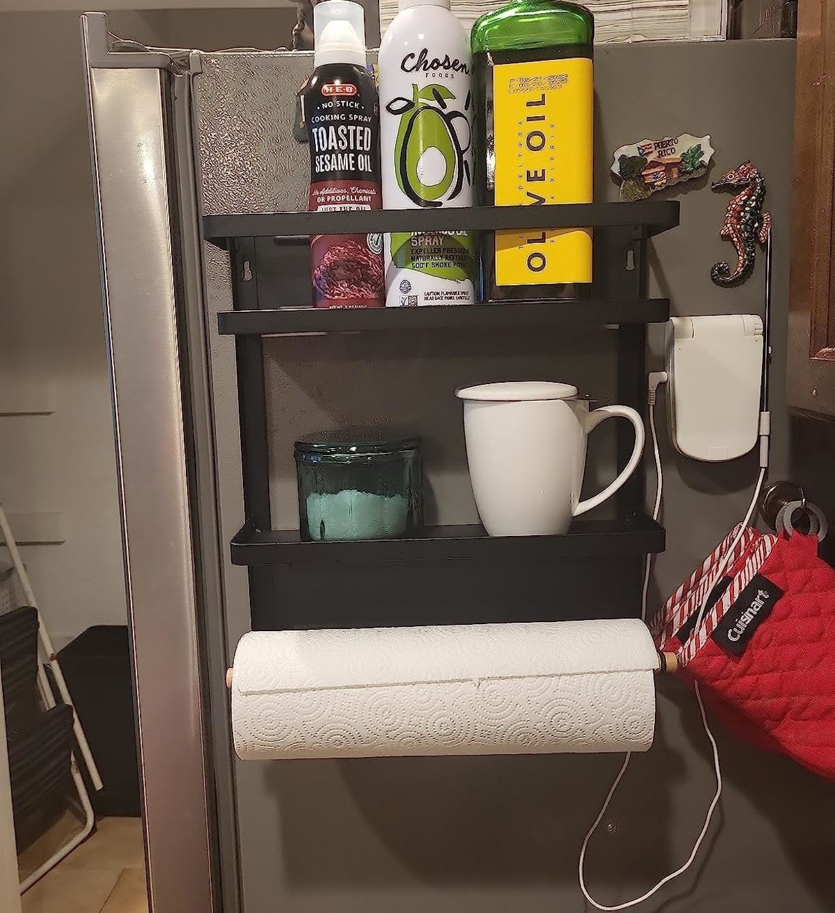 Reviewer's rack on fridge storing oils, mug, and paper towels