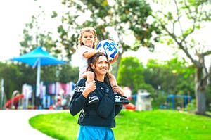 Alex Morgan stands with her daughter Charlie on her shoulders