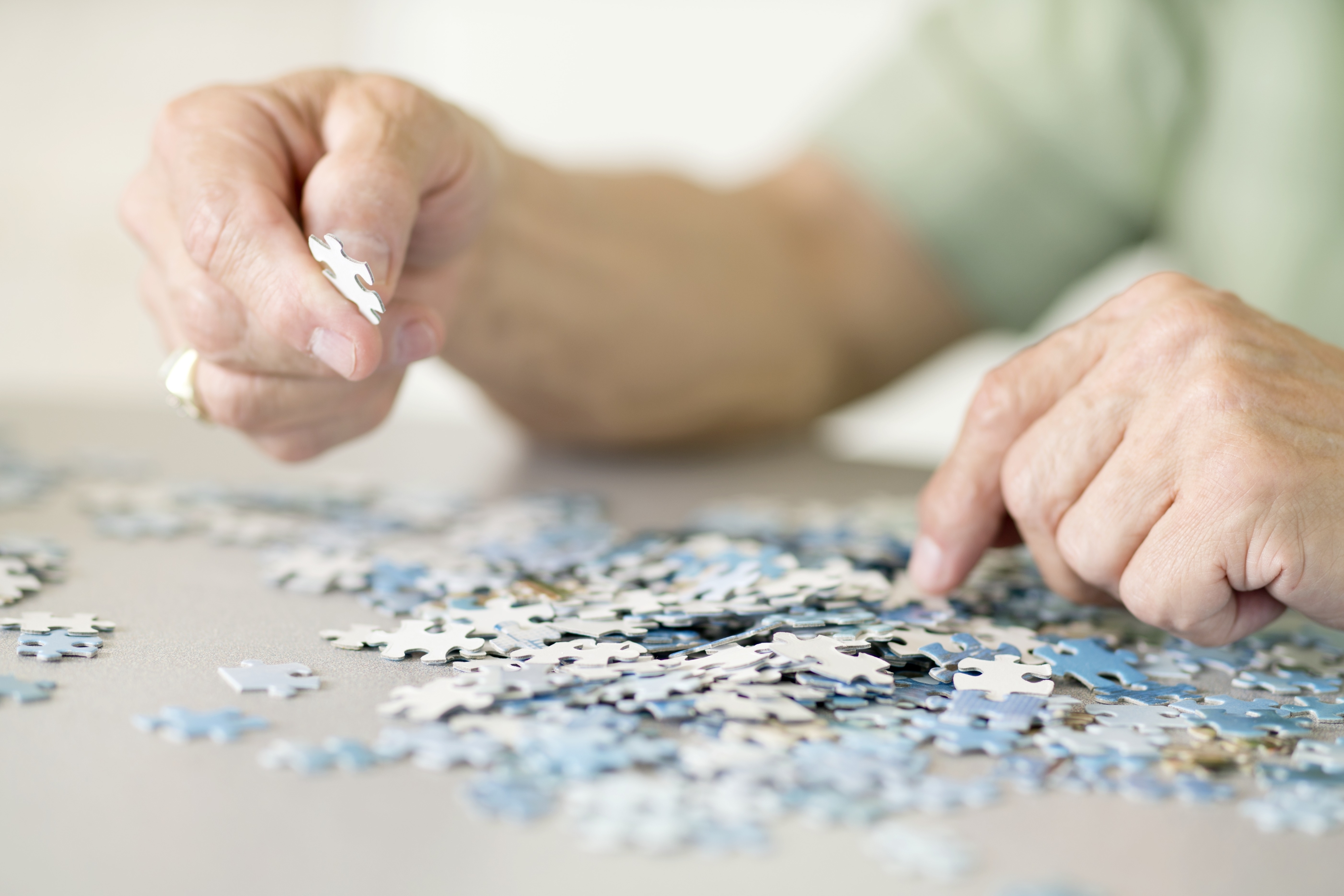 An adult works on solving a jigsaw puzzle