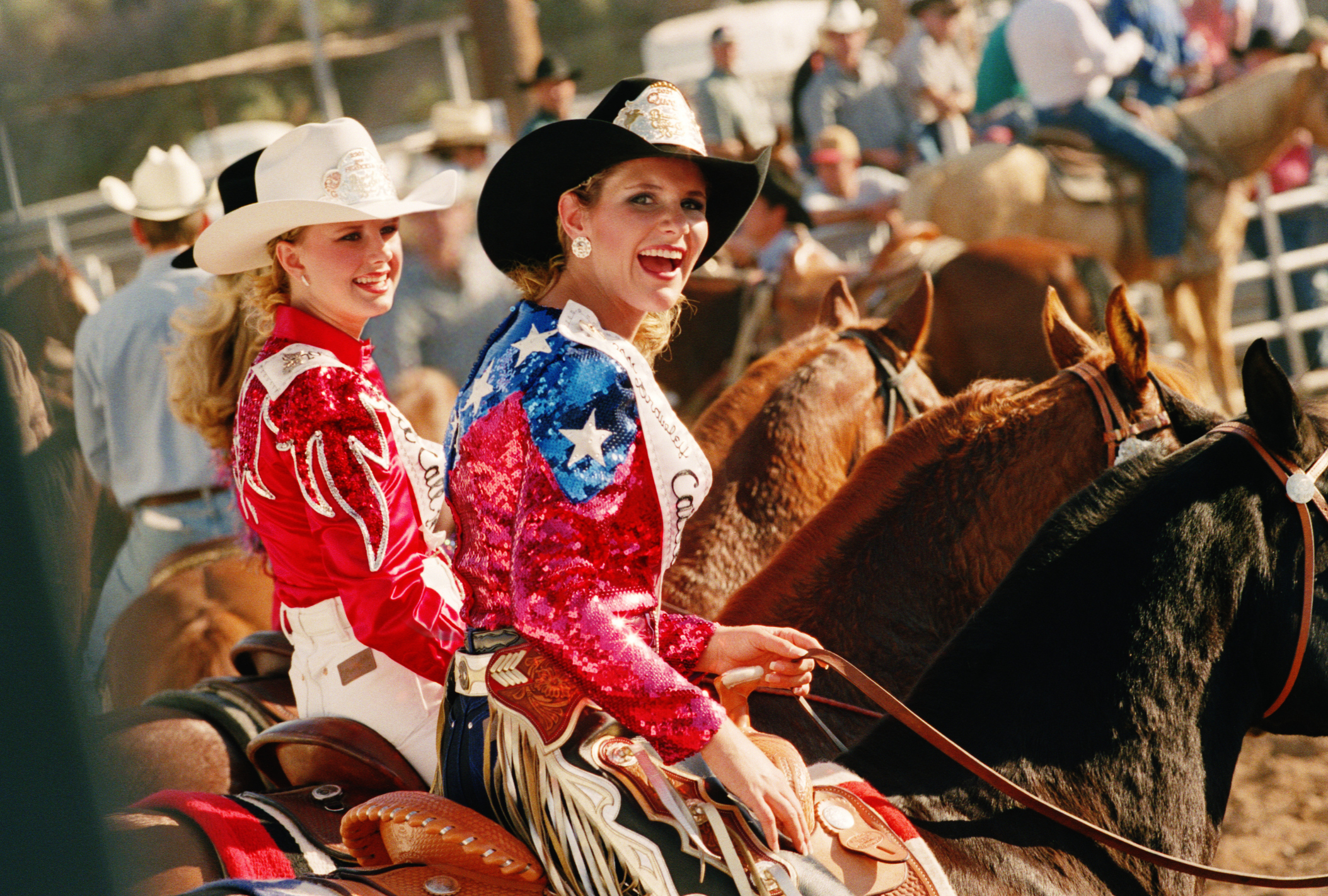 Waist-up shot of two rodeo queens on horses