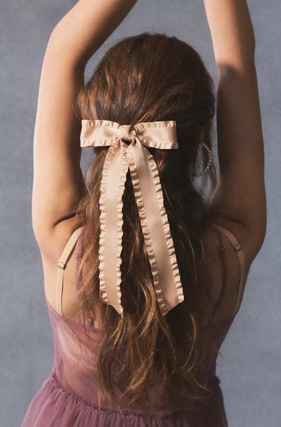 a model wearing the pink hair bow barrette