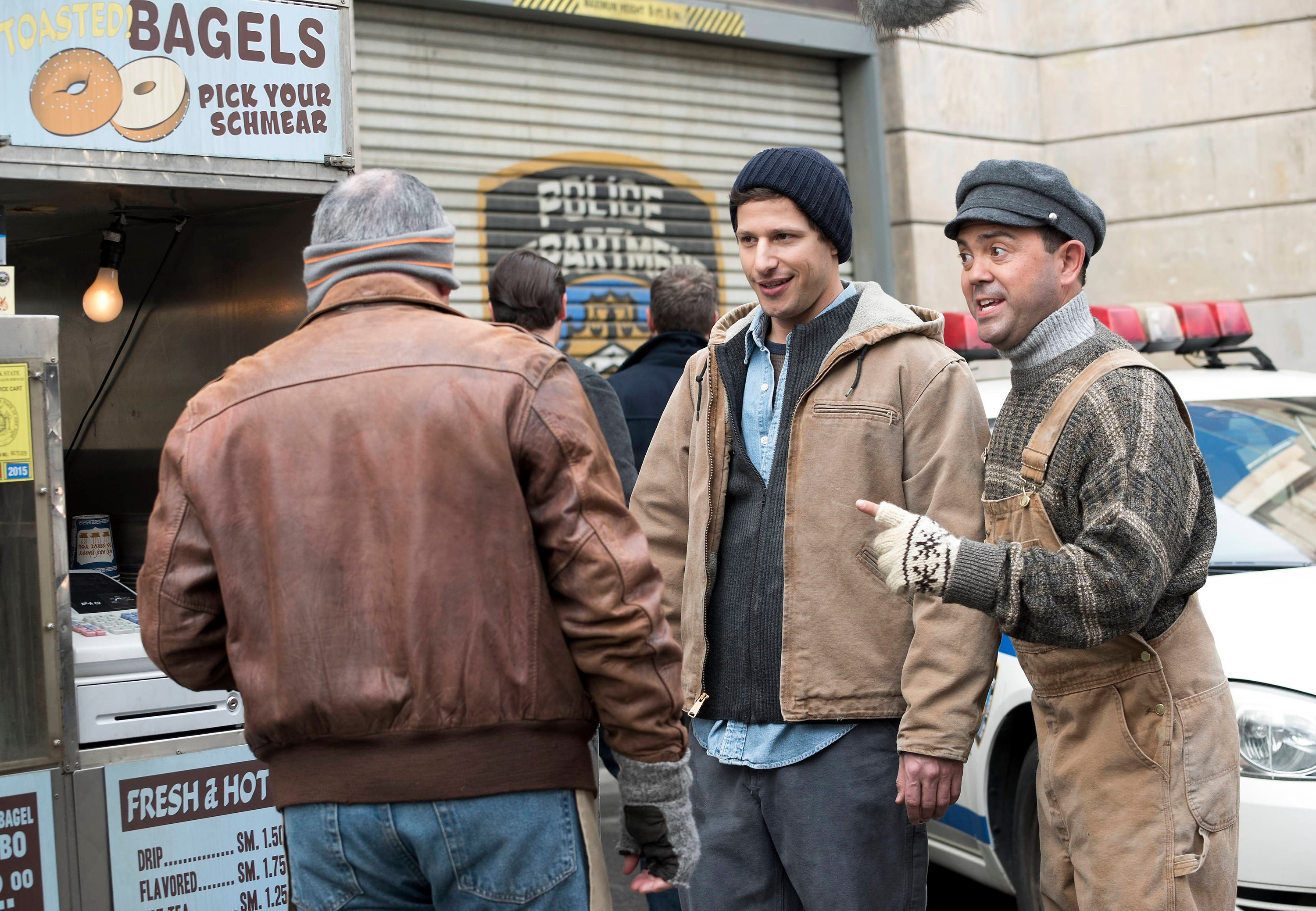 Andy Samberg and Joe Lo Truglio wear layers while posing as blue collar workers
