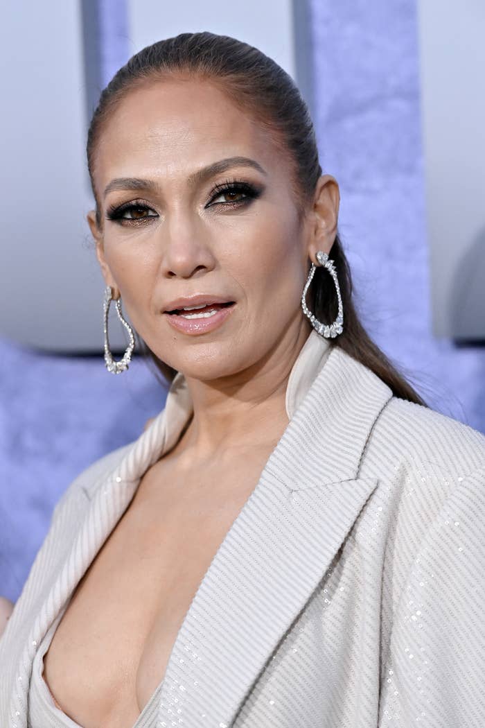 A closeup of Jennifer Lopez at a media event with her hair pulled back into a sleek ponytail