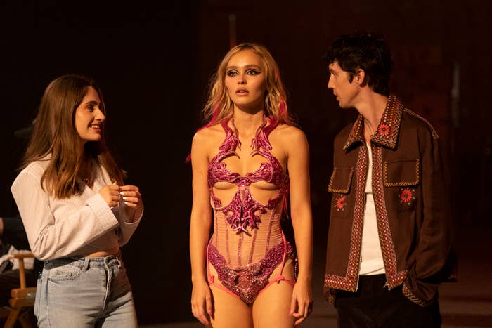 lilly rose depp standing in the middle of two other people wearing a stage bodysuit with cutouts
