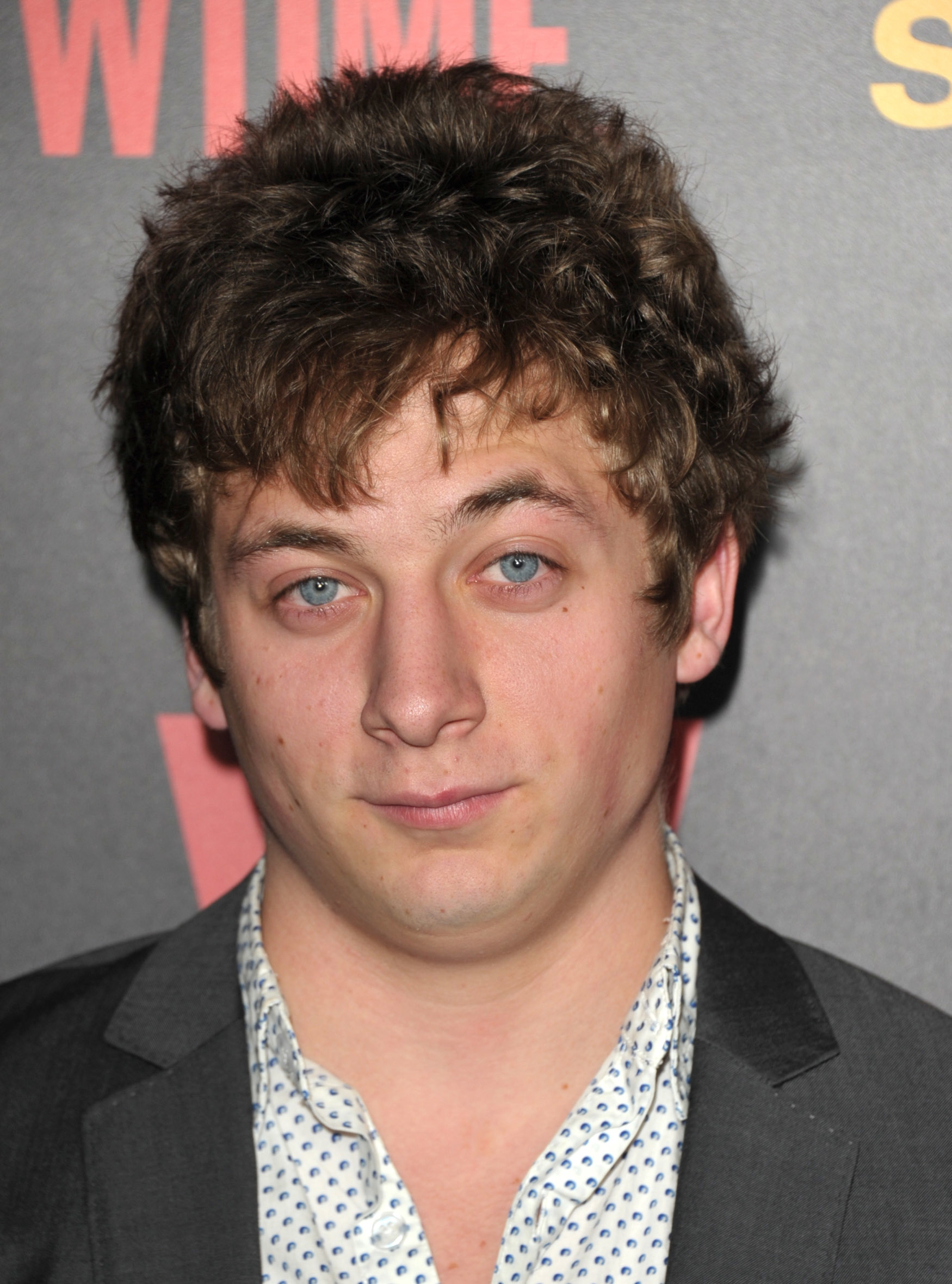 Jeremy Allen White in a dark jacket and collared shirt with at the premiere of Shameless Season 2. At the time, Jeremy had short hair