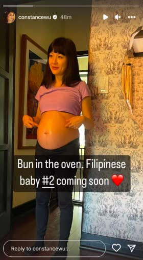 Constance Wu points at her baby bump