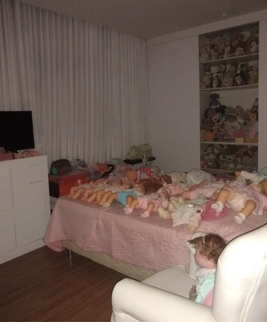 A room full of dolls laying on a bed