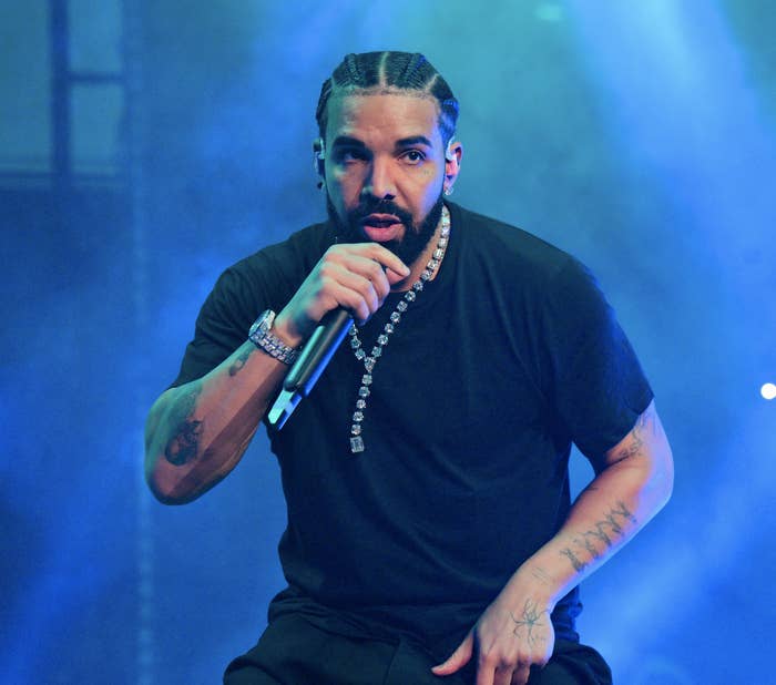 Drake performing on stage in a plain t-shirt and a large diamond chain