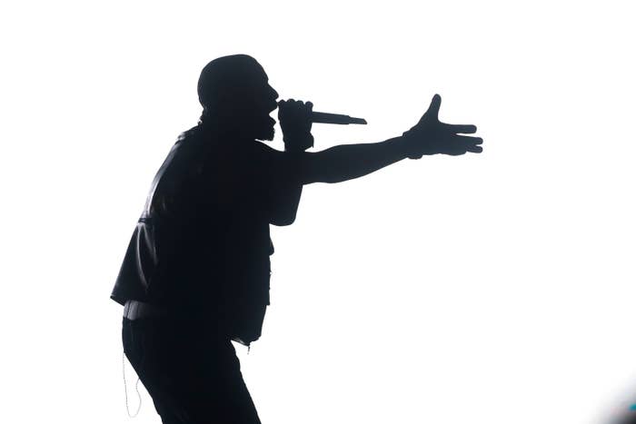 A silhouette of Kanye West performong