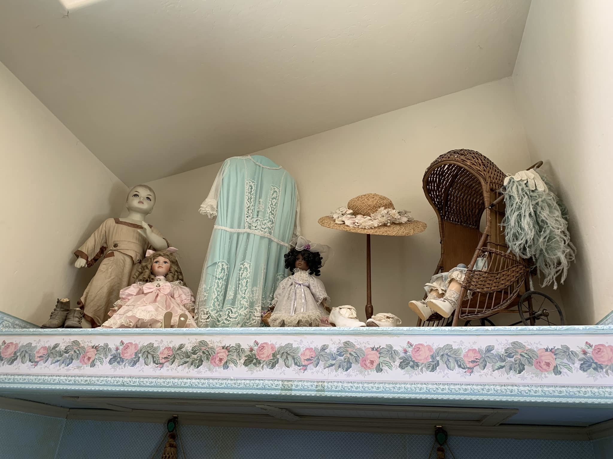 Antique dolls and furntiure kept on a shelf in a bathroom