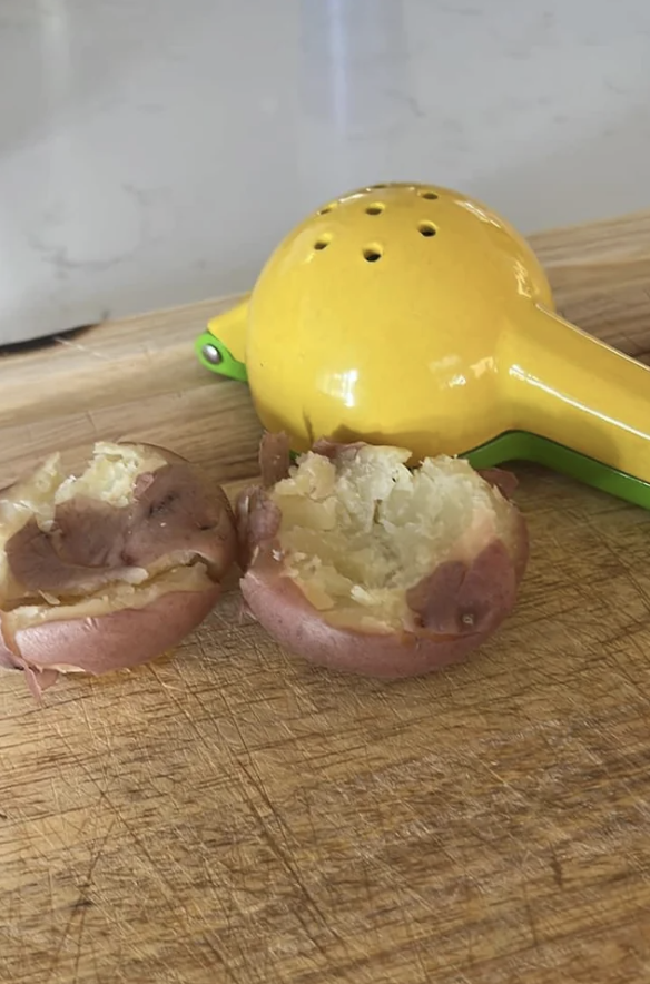 A lemon juicer next to red potatoes