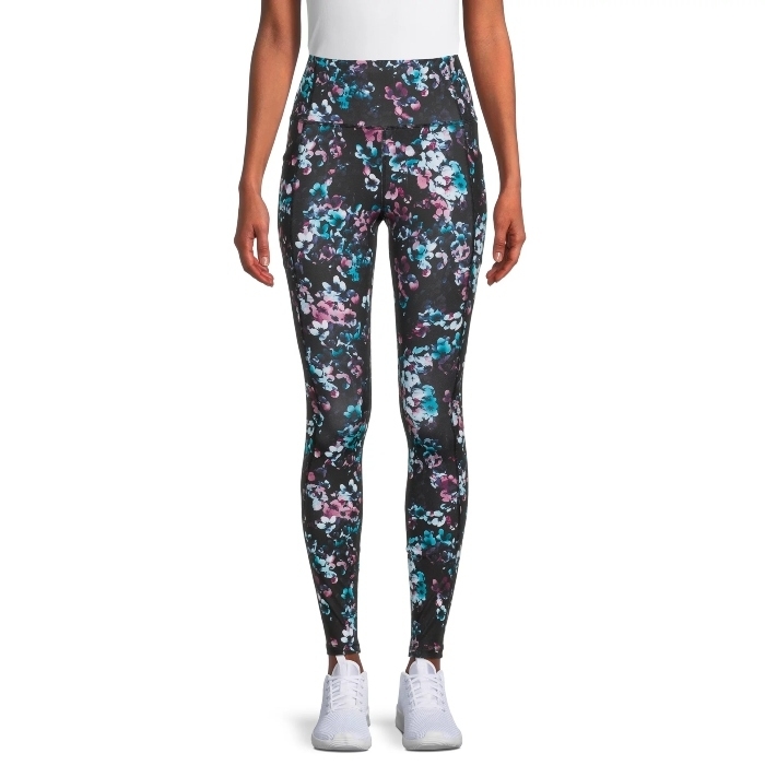 model wearing black printed leggings with pink and blue florals, and white sneakers