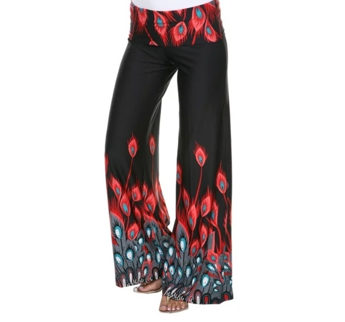 model wearing wide leg black pants with red and blue peacock print and sandals