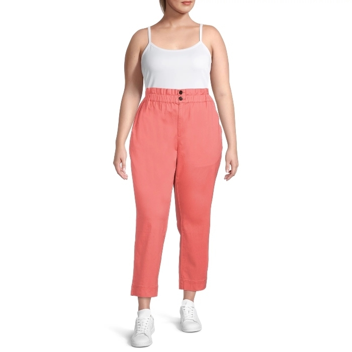 model wearing coral pants that hit above the ankles and white sneakers