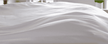 gif of a sheet being fluffed onto a bed
