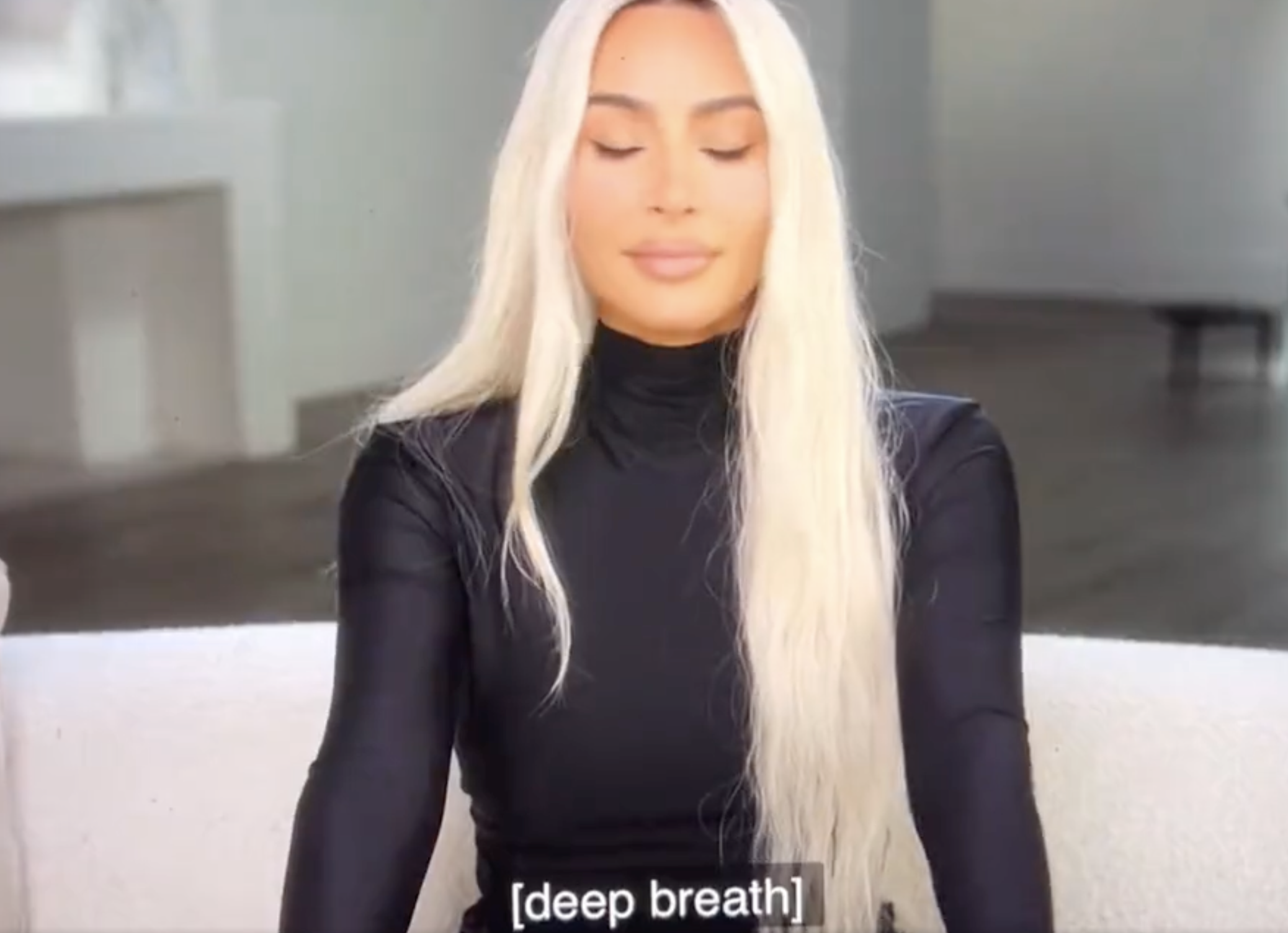 Close-up of Kim with long, platinum blonde hair and her eyes closed