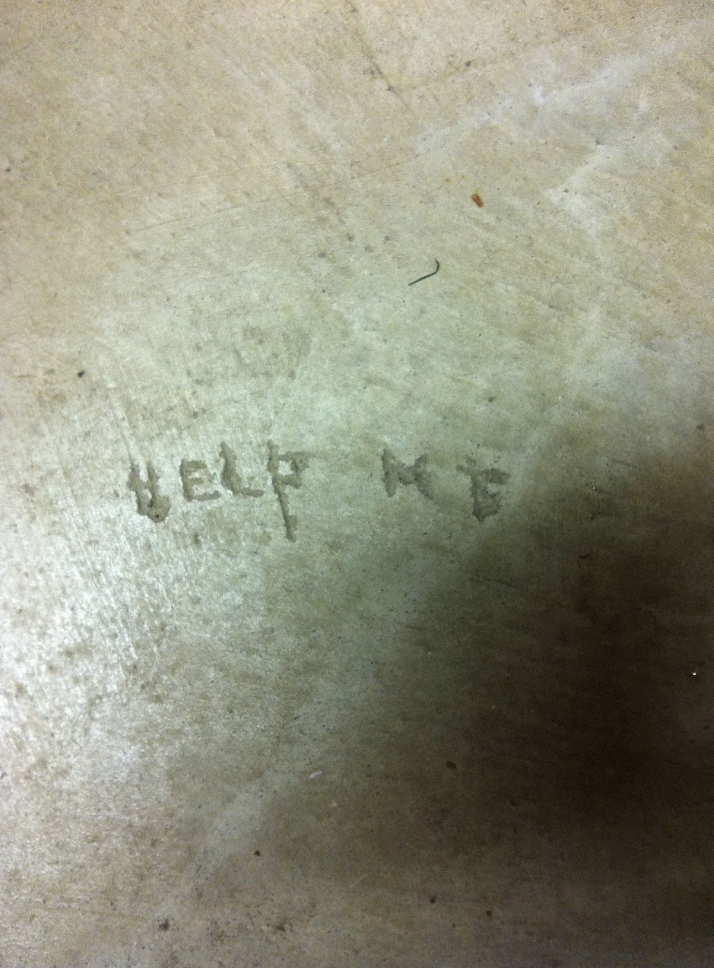 &quot;Help me&quot; carved on a floor