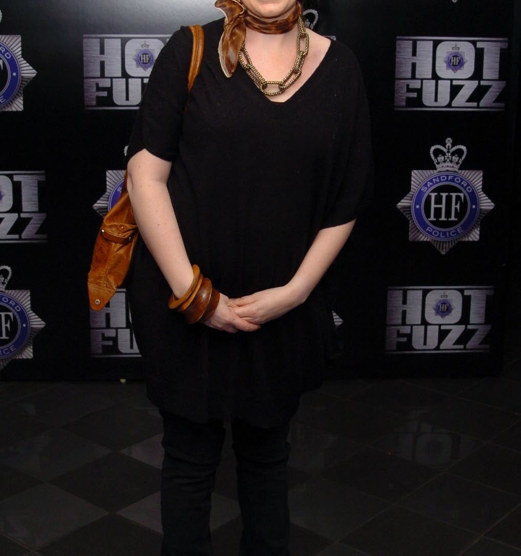 Olivia Colman at the premiere of Hot Fuzz wearing all black with leather accessories and a haircut with bangs