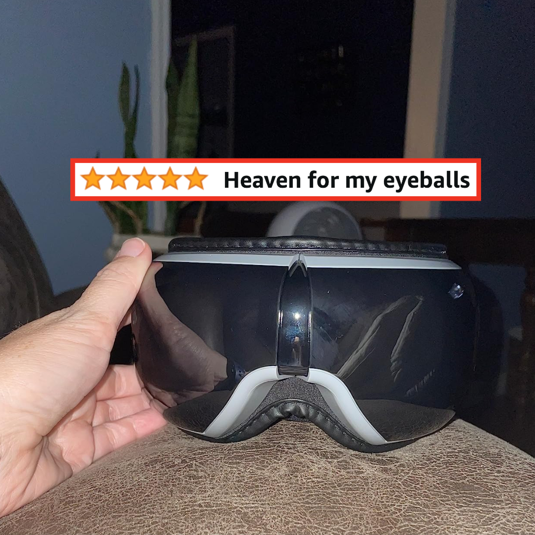 Reviewer holding their black eye massager with words &quot;Heaven for my eyeballs&quot;
