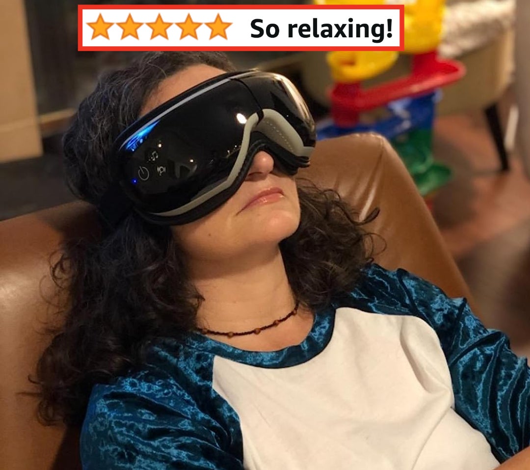 Reviewer wearing the black eye massager with words &quot;So relaxing!&quot;