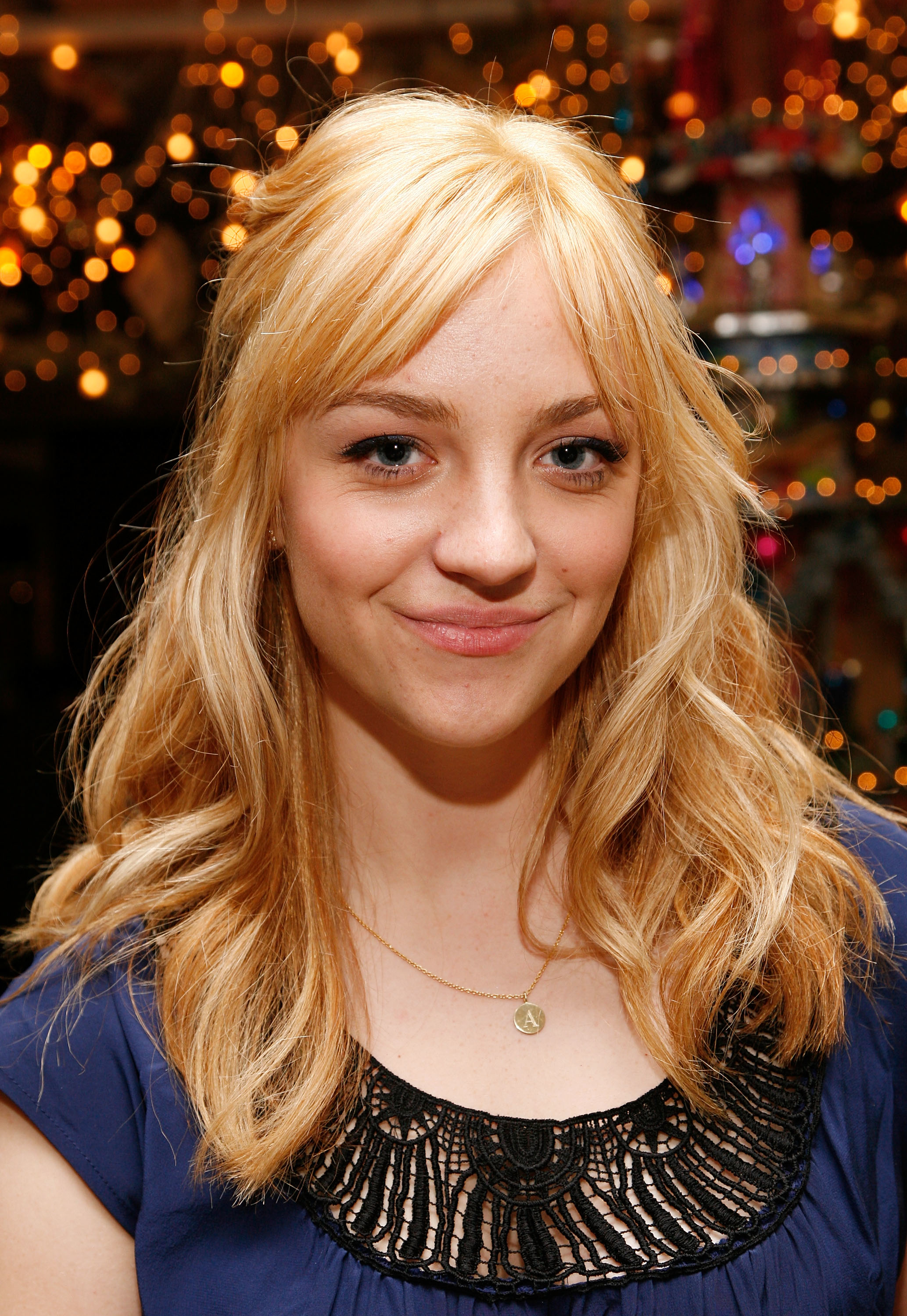 A closeup of Abby Elliott with shoulder-length wavy hair and bangs