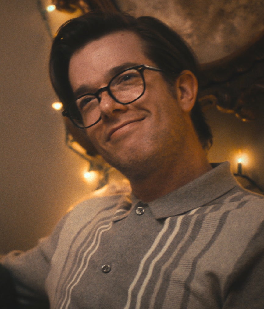 John Mulaney wearing glasses and a striped button-up in The Bear
