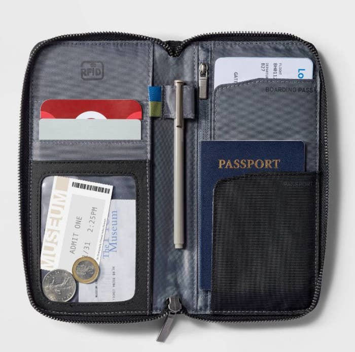 an open passport wallet showing pockets to hold a passport, tickets, cards, and coins