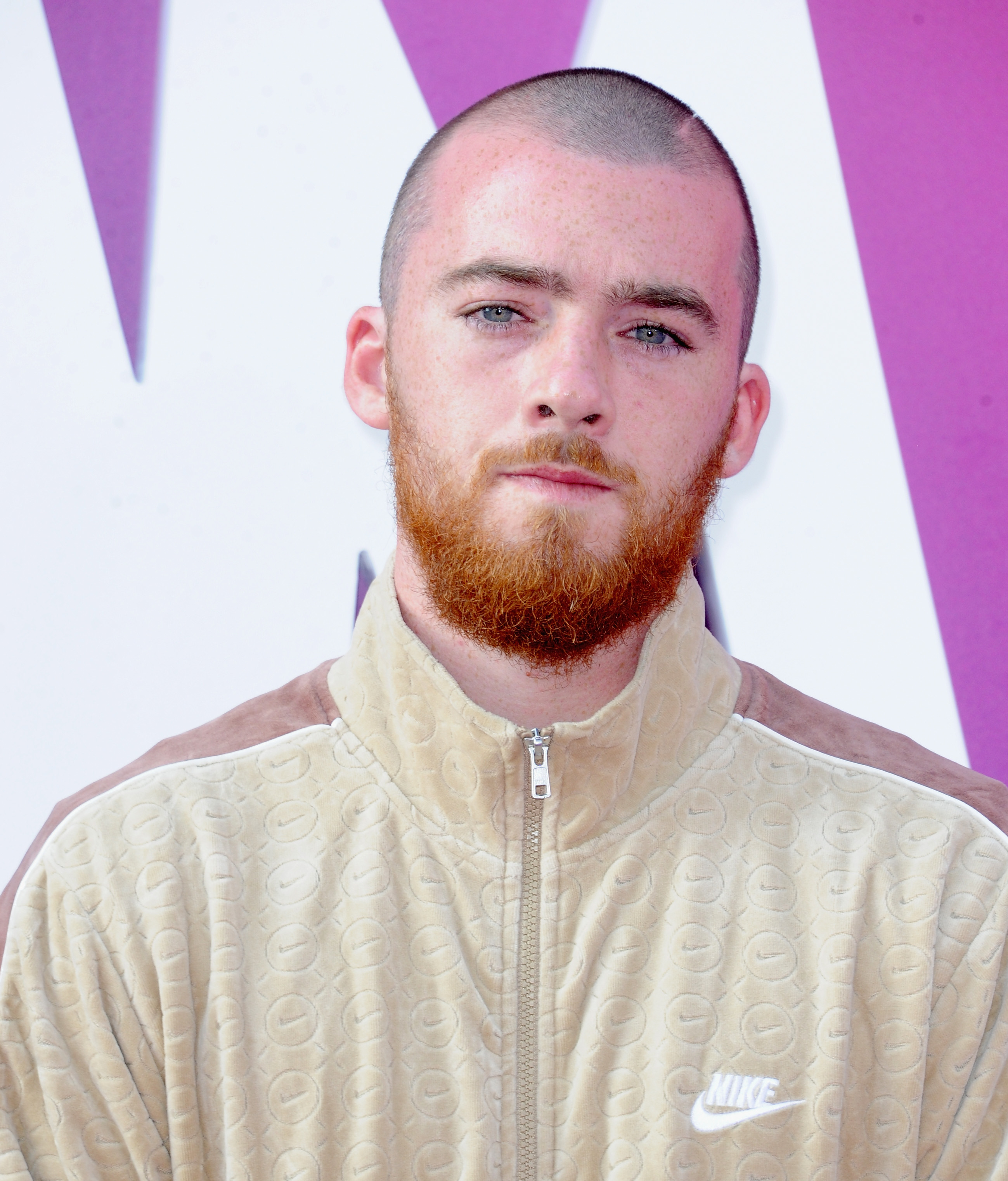 Close-up of Angus in a velour tracksuit at a press event