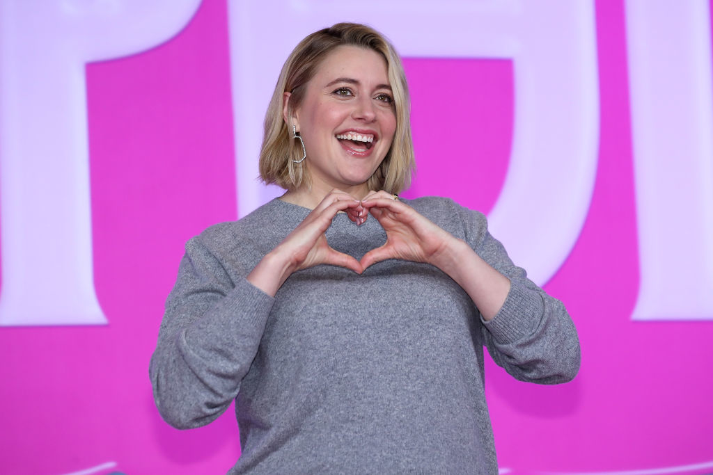 Greta holding up her hands in a heart at a barbie event in south korea