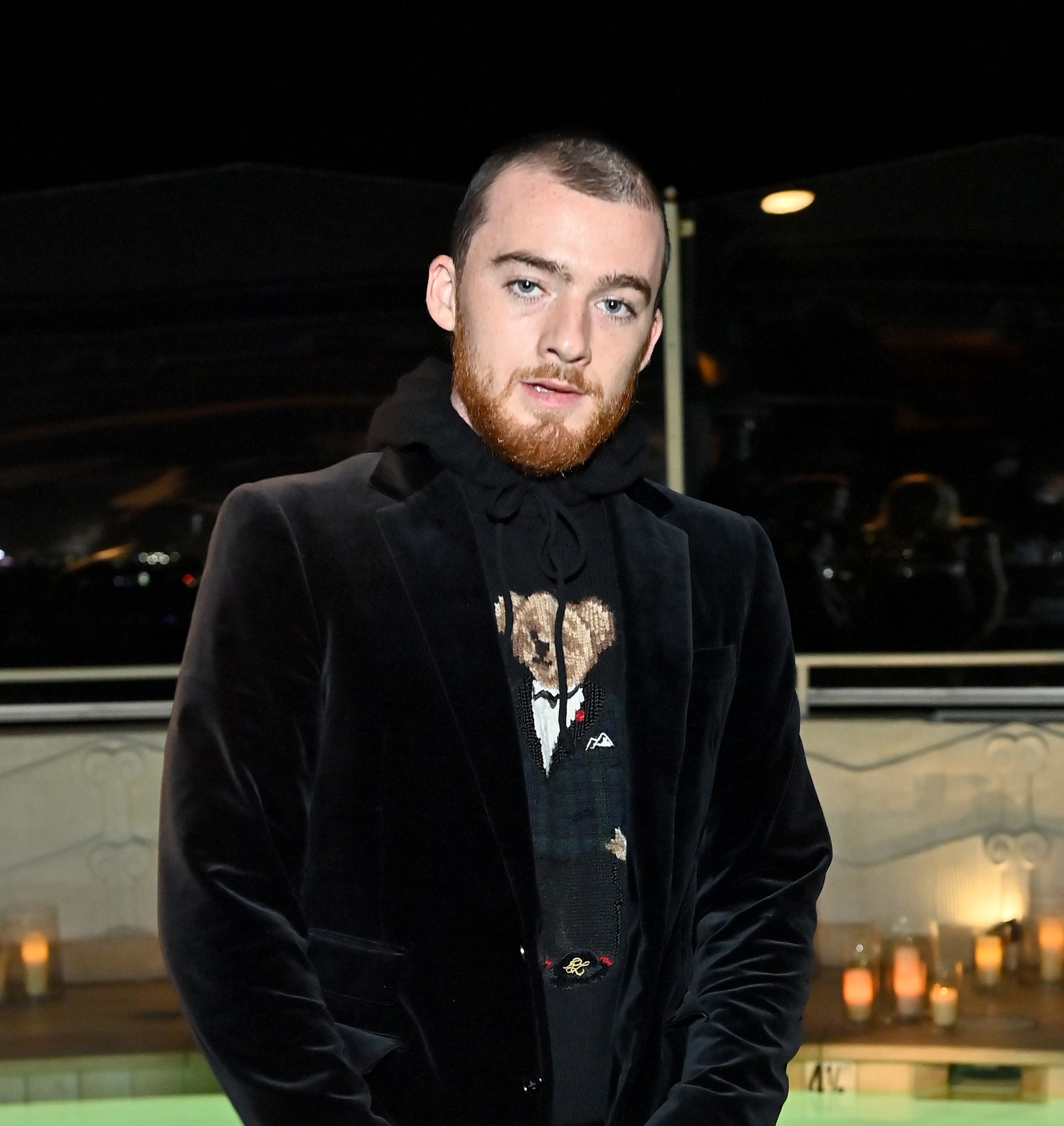 Close-up of Angus in a velour suit jacket and hoodie